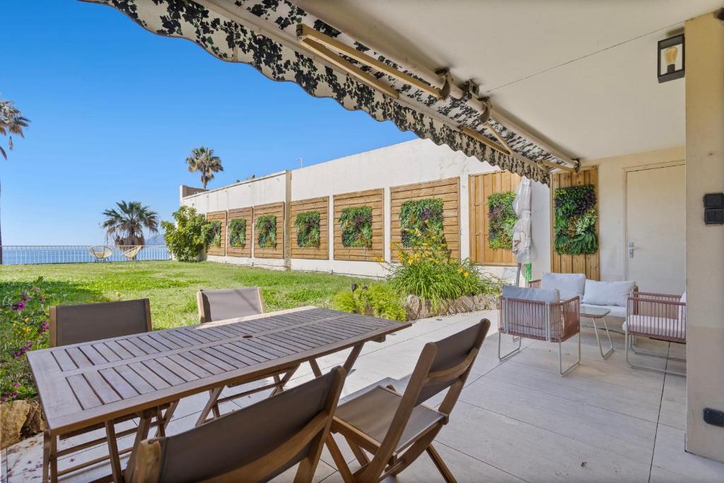 un patio avec une table et des chaises et l'océan dans l'établissement REF 2004 - Cannes - Sea view apartment for rent, à Cannes