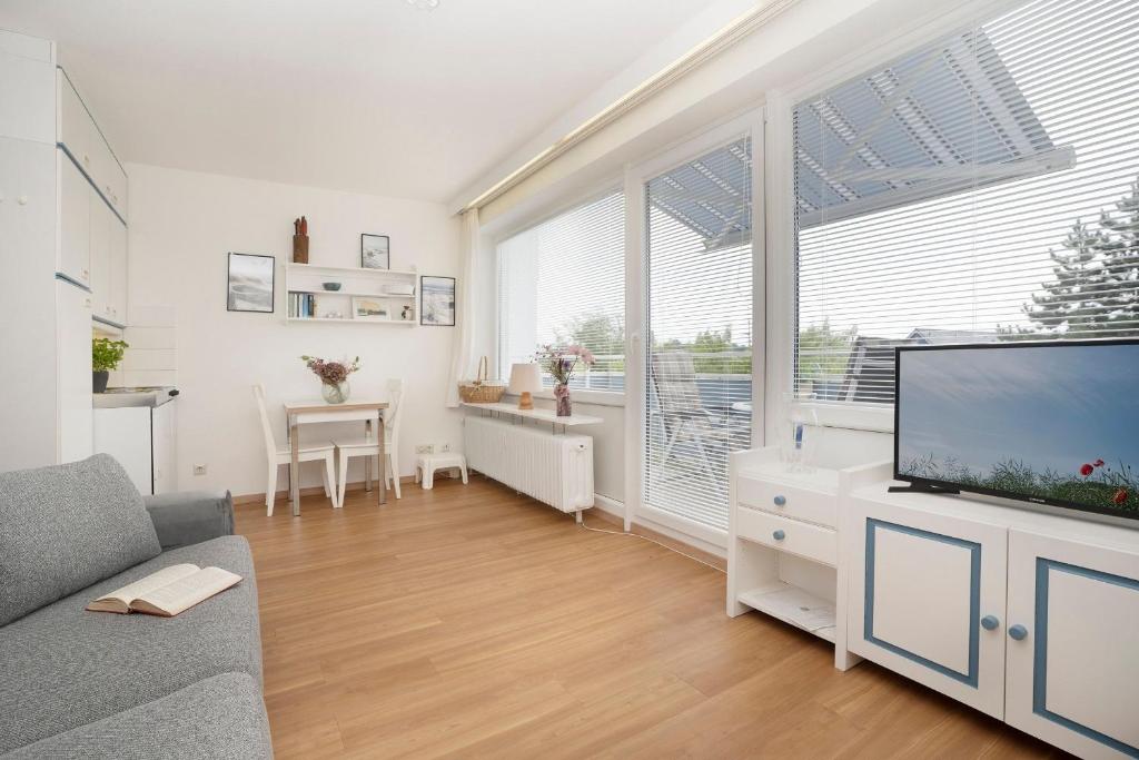 a living room with a large window and a tv at Strandhotel Scharbeutz Kleine Krabbe in Scharbeutz