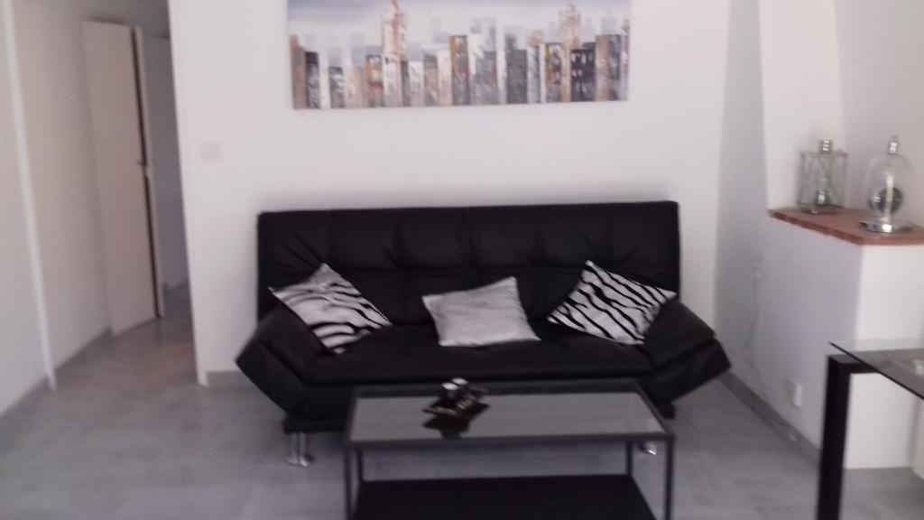 - un canapé noir dans le salon avec une table dans l'établissement RDJ dans villa Antibes, à Antibes