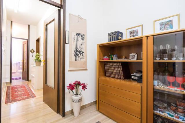 Una habitación con un jarrón con flores rojas. en Duomo 15 minuti, en Milán