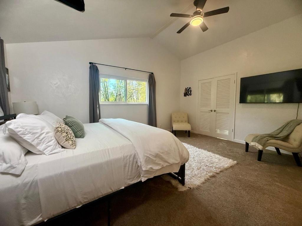 a bedroom with a bed and a ceiling fan at The Happy Cabin w/ hot tub in Oakhurst