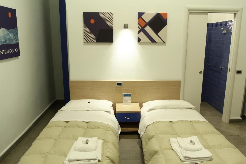 two beds in a hospital room with towels on them at Affittacamere del Golfo e delle 5 Terre in La Spezia