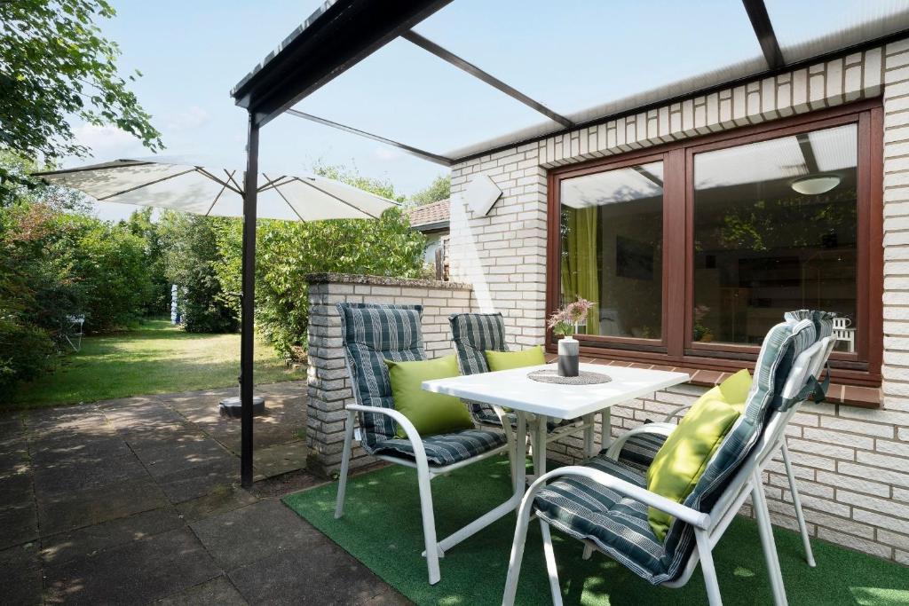 a patio with a table and chairs and an umbrella at Zwergi in Grömnitzerhagen
