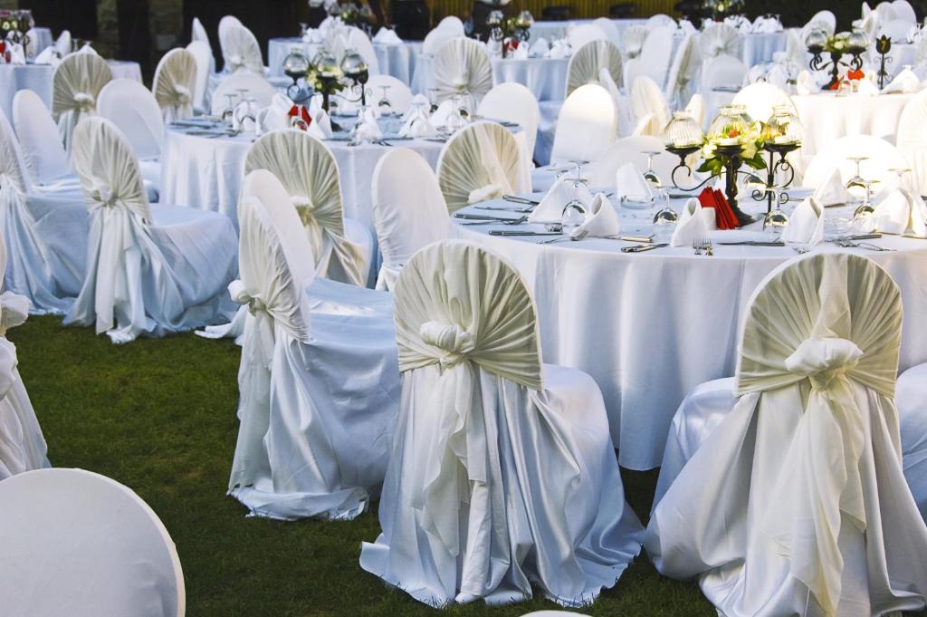 a group of tables with white chairs and tablesearcher at Metropolitan Al Mafraq Hotel in Abu Dhabi