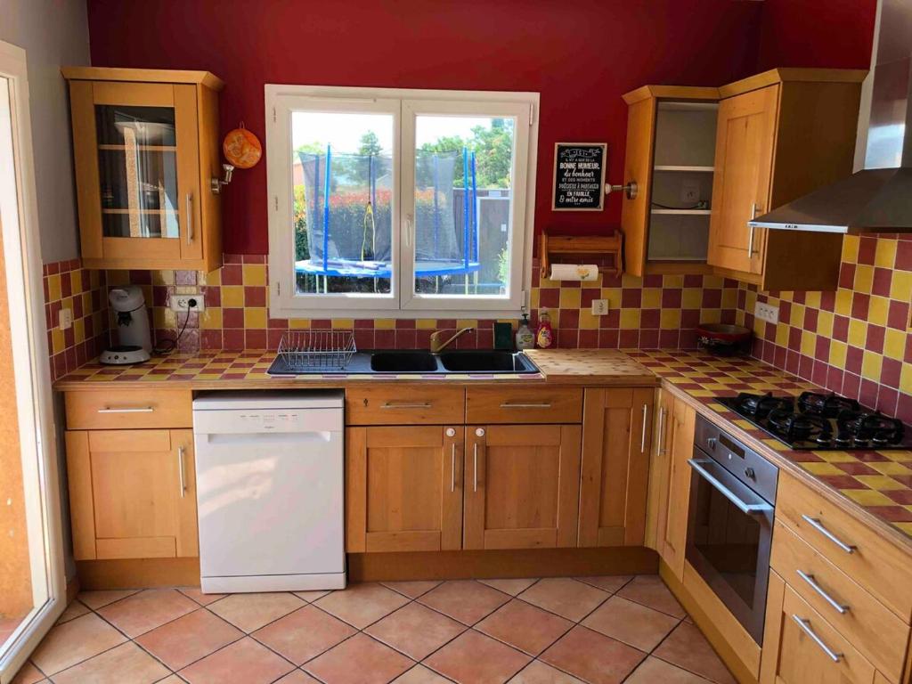 une cuisine avec des armoires en bois, un évier et une fenêtre dans l'établissement Mediterranean villa with pool!, à Millau