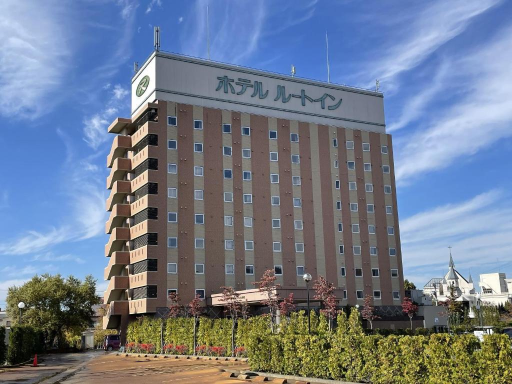 a building with a clock on the top of it at Hotel Route-Inn Aizuwakamatsu in Aizuwakamatsu