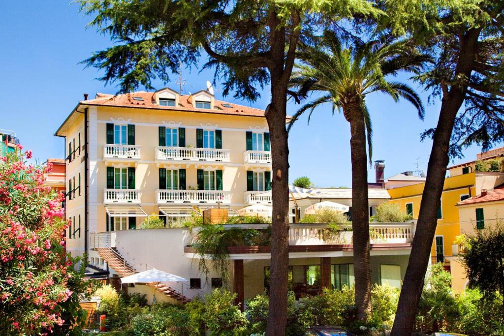 un edificio con palmeras delante en Hotel Lamberti, en Alassio