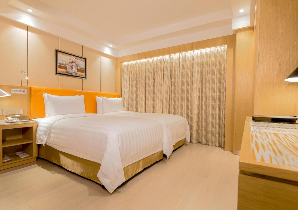 Postel nebo postele na pokoji v ubytování Royal Dragon Hotel