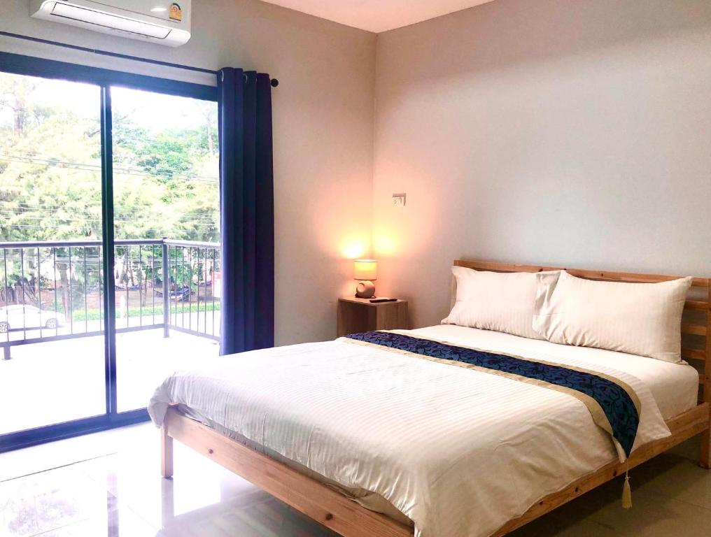 a bedroom with a bed and a large window at Emma in Ban Pak Khlong Phe