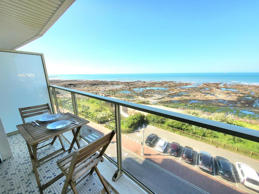 un balcon avec une table et une vue sur l'océan dans l'établissement Appartement T3 rénové, face mer avec garage et WiFi, aux Sables d'Olonne - FR-1-92-919, à Les Sables-dʼOlonne