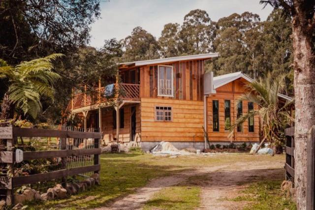 a wooden house with a fence in front of it at pousada e camping recanto do riacho in Urubici