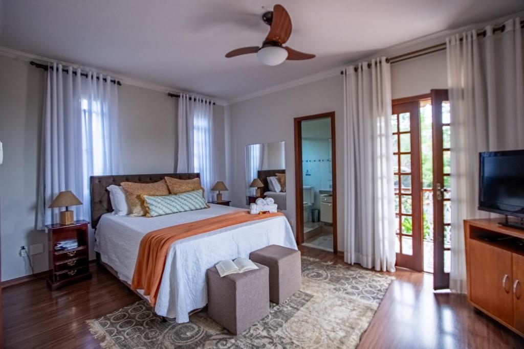 a bedroom with a bed and a ceiling fan at Maravilhosa casa com piscina em Lagoa Santa in Lagoa Santa