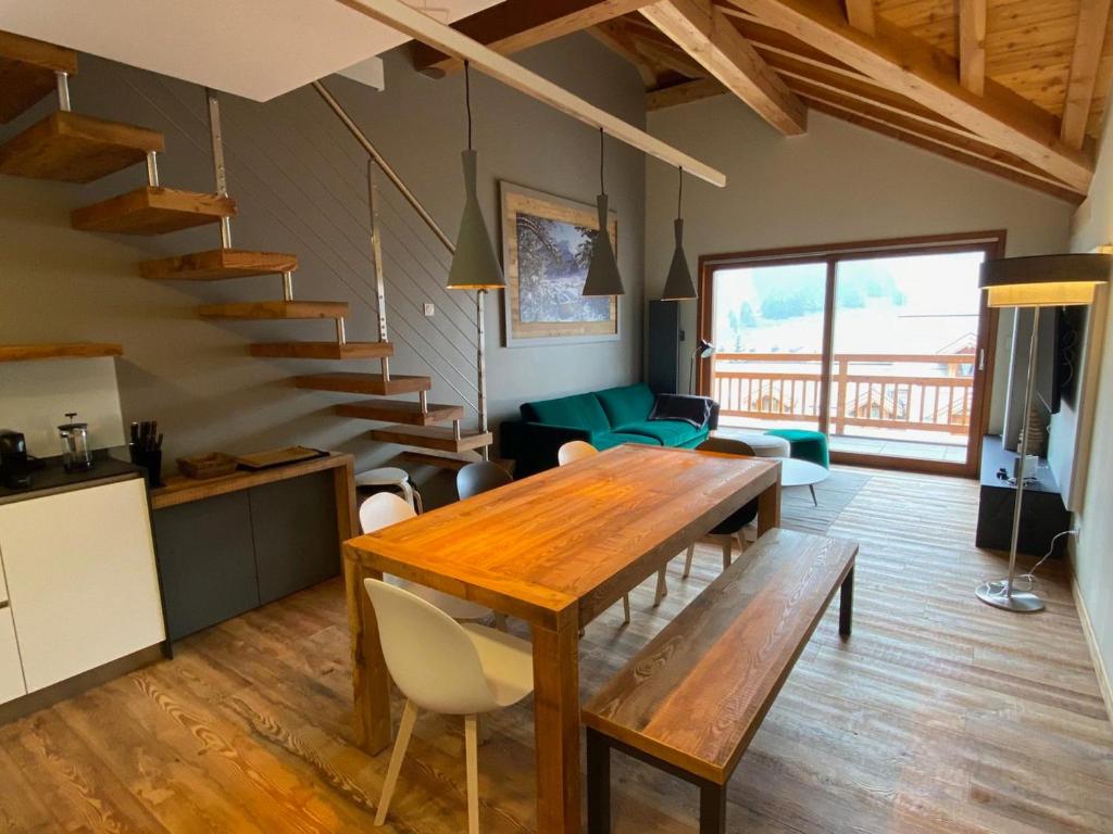 a living room with a wooden table and a staircase at Duplex de luxe 96m² - Terrasse - Ski au pied - 9 Pers. - FR-1-445-221 in Montgenèvre