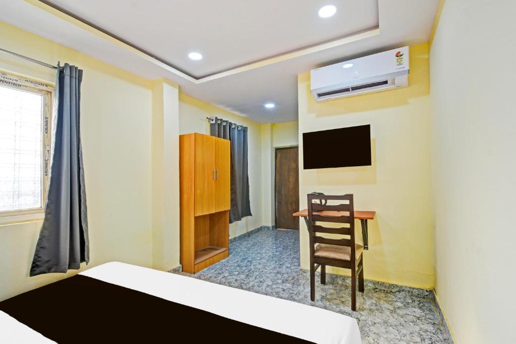 a bedroom with a bed and a chair and a desk at Super Hotel O Madlen in Hyderabad