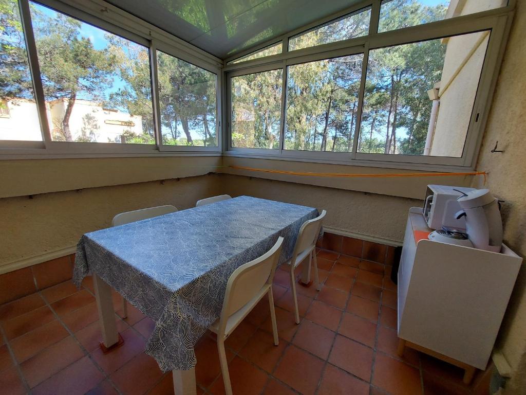 une salle à manger avec une table, des chaises et des fenêtres dans l'établissement Appartement 2 pièces avec loggia à 150m de la plage, animaux acceptés, garage compris - FR-1-776-111, à Argelès-sur-Mer