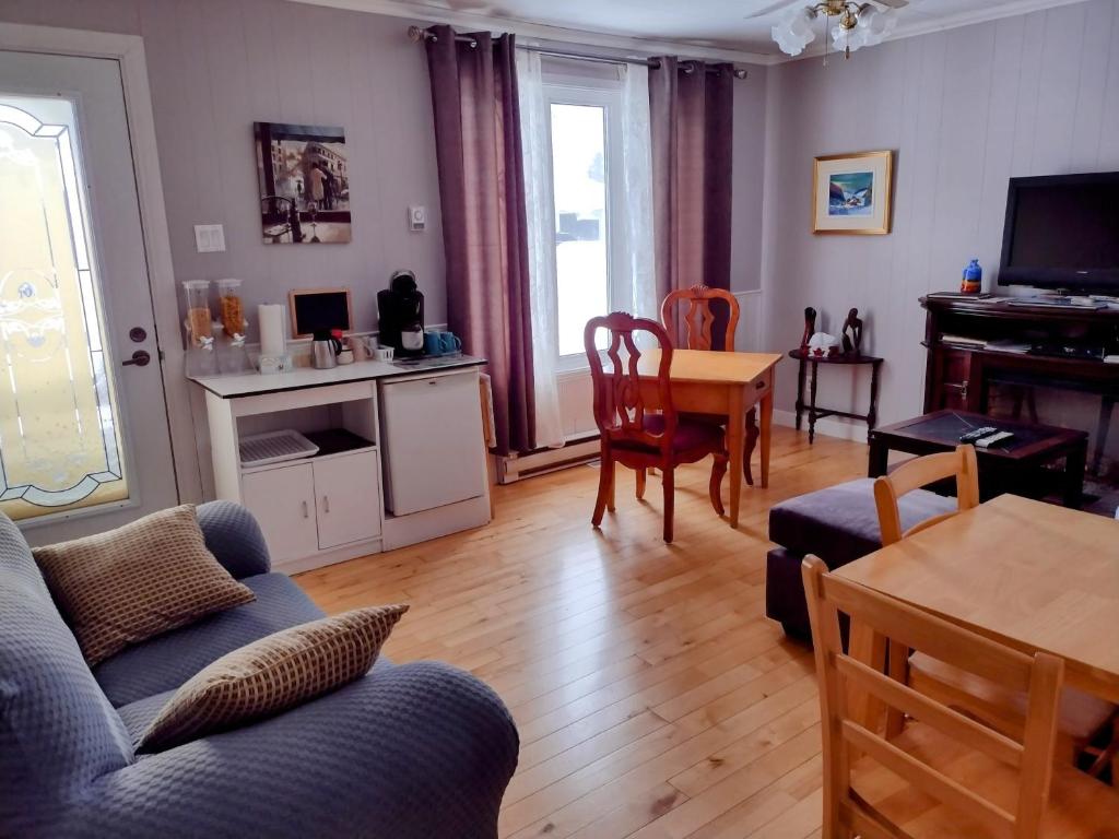 uma sala de estar com um sofá e uma mesa em Gîte Marie-Claire em Petit-Saguenay