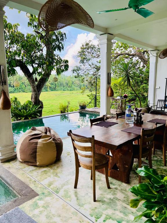 a dining room with a table and chairs and a pool at Villa Seven Faces-Luxury Escape,Stunning Views with Private pool for a Couple or family! in Galle