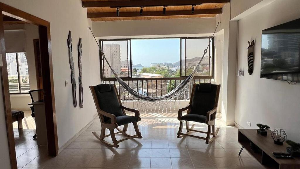 a living room with two chairs and a large window at Apartamento Familiar en Rodadero in Rodadero
