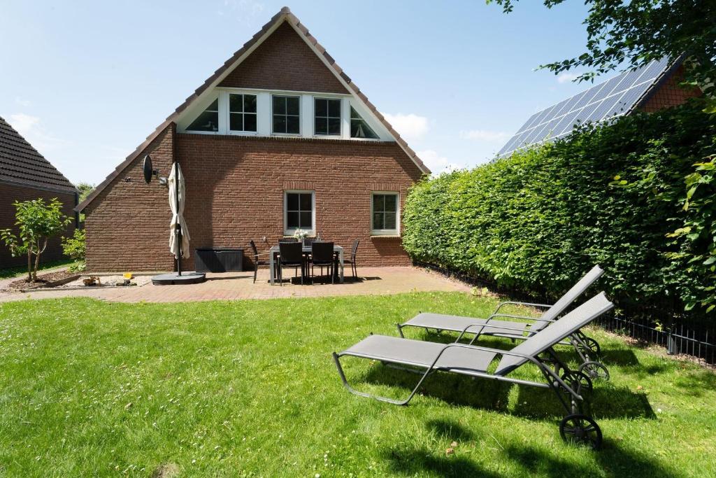 un banc dans l'herbe devant une maison dans l'établissement Dat Ostseehus, à Kraksdorf