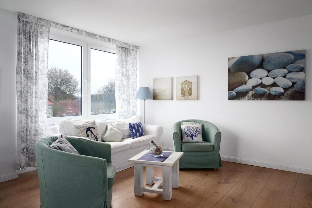 a living room with two chairs and a couch and a table at Dorfring 36 Albatros in Stein