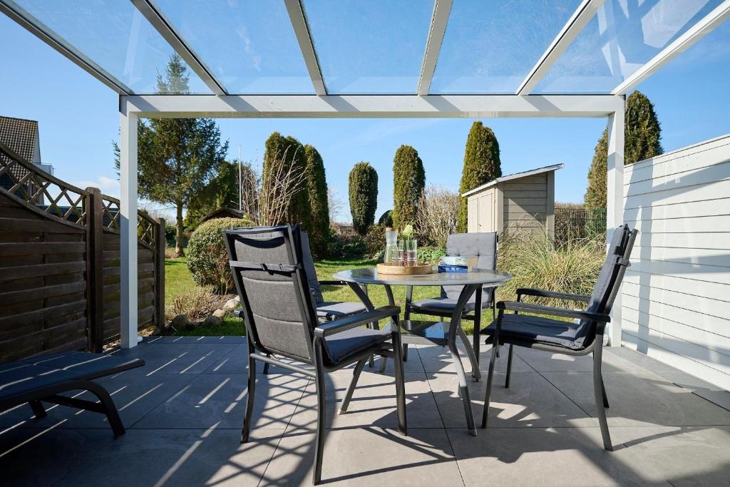 a patio with a table and chairs and a pergola at Schlehenkamp 5 Meerglück in Schönberg