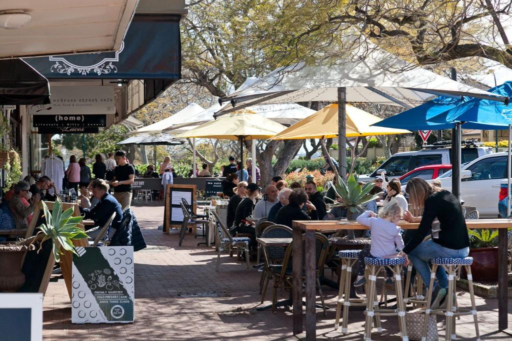 un groupe de personnes assises à des tables dans un restaurant en plein air dans l'établissement Serene Stay Near Perth & Freo, à Bicton