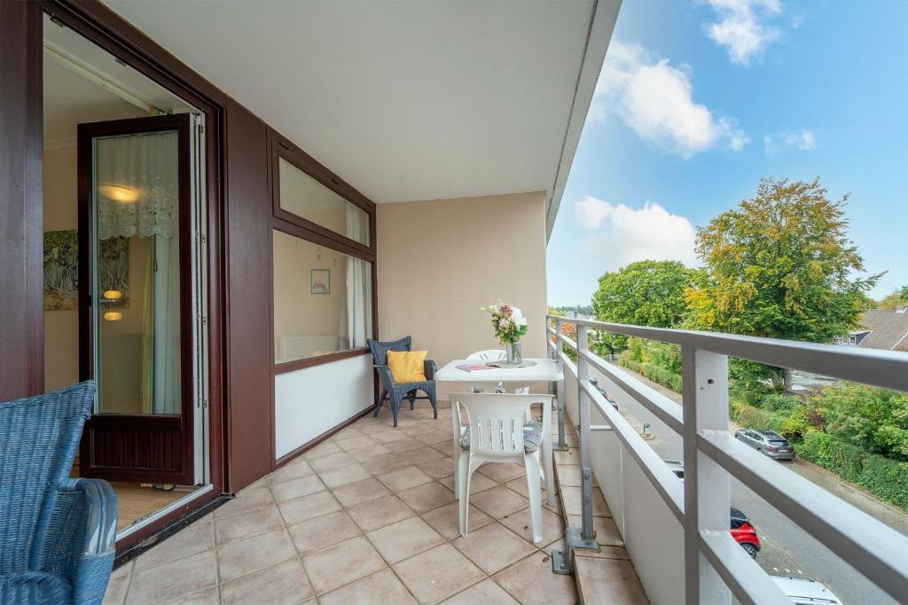 Un balcón de una casa con una mesa y sillas. en Strandappartements am Leuchtturmweg Leuchtturmblick, en Kellenhusen