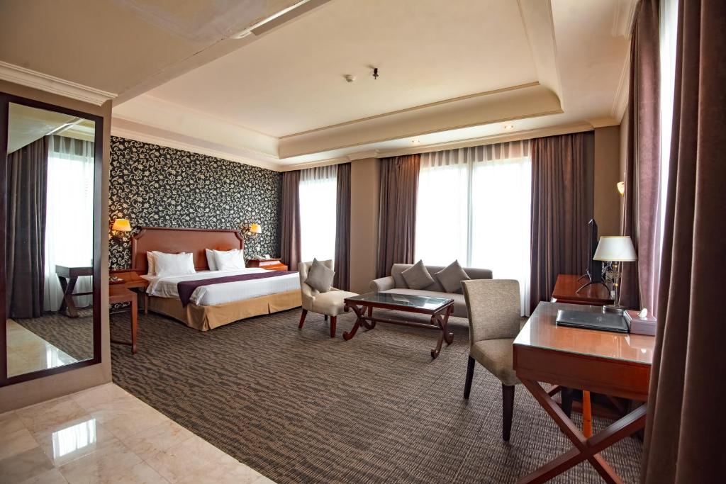 Postel nebo postele na pokoji v ubytování The Mirah Hotel Bogor