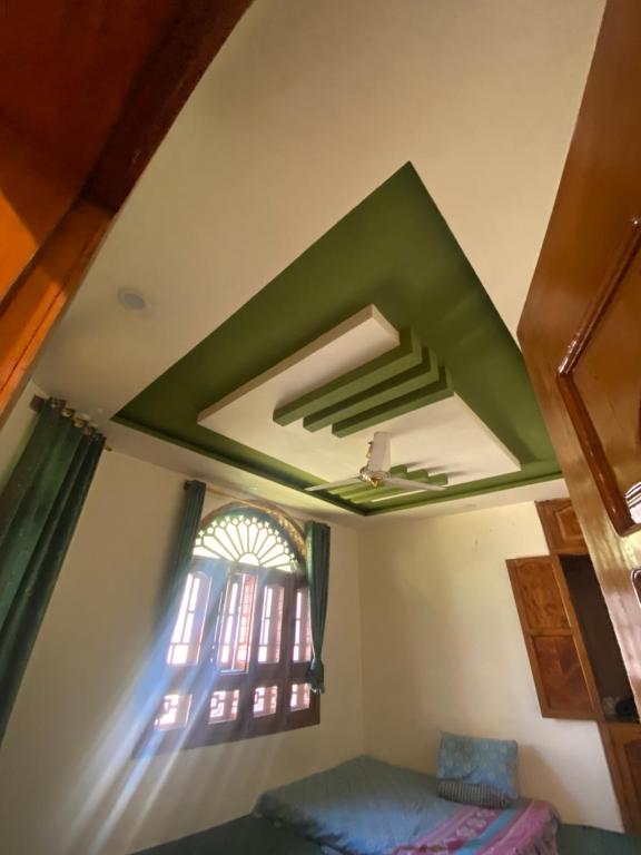a room with a green ceiling and a window at Raheel house in Dargai