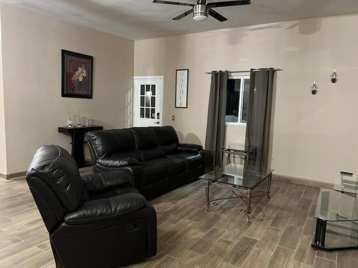 sala de estar con sofá de cuero negro y mesa de cristal en Casa Las Vias 6 bed 4 bath & Private Pool, en Puerto Peñasco