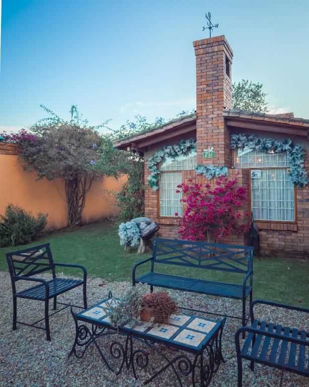 een patio met 2 banken en een tafel met bloemen bij Cabaña en el casco urbano de Subachoque in Subachoque
