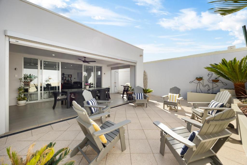a patio with rocking chairs and a living room at Parea on Cavendish - A Perfect Beachside Lifestyle in West Beach