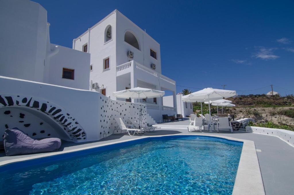 una piscina frente a un edificio blanco en Belle Etoile Villas, en Imerovigli