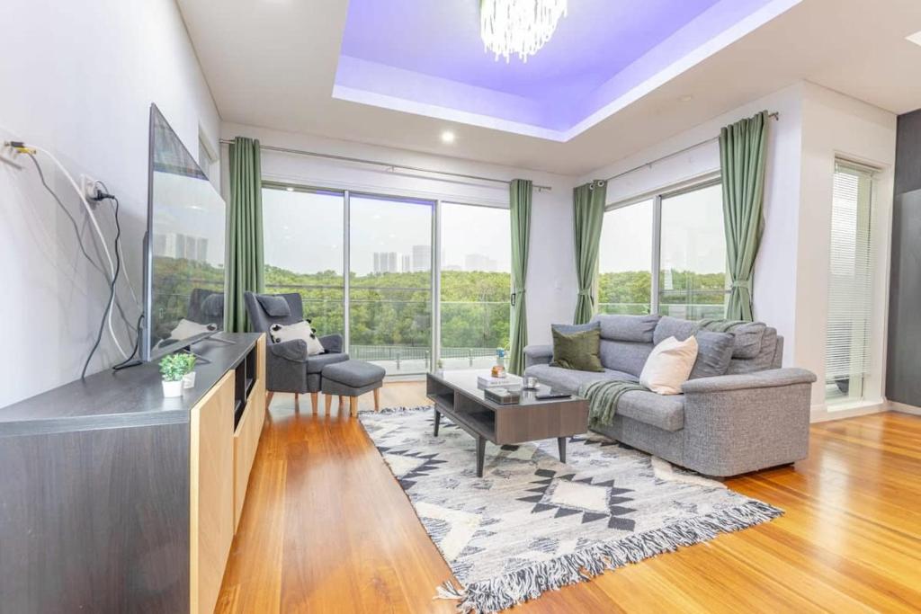 Una sala de estar con un sofá y un televisor. en Luxury 5BD house w water view in Melrose Park, en Sídney