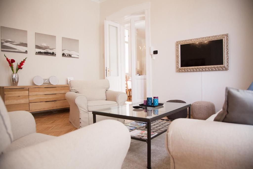ein Wohnzimmer mit einem Tisch und Stühlen in der Unterkunft City Apartment Budapest in Budapest