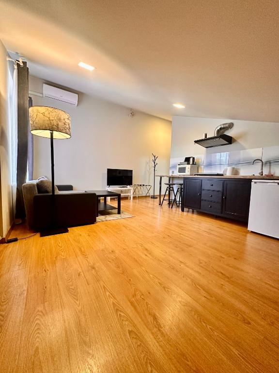an empty living room with a wooden floor and a table at Perlos Apartamentai 13 in Birštonas