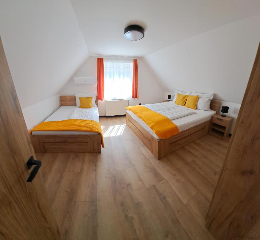 sypialnia z dwoma łóżkami i oknem w obiekcie Relax Apartman Bükfürdő w Bukfurdo