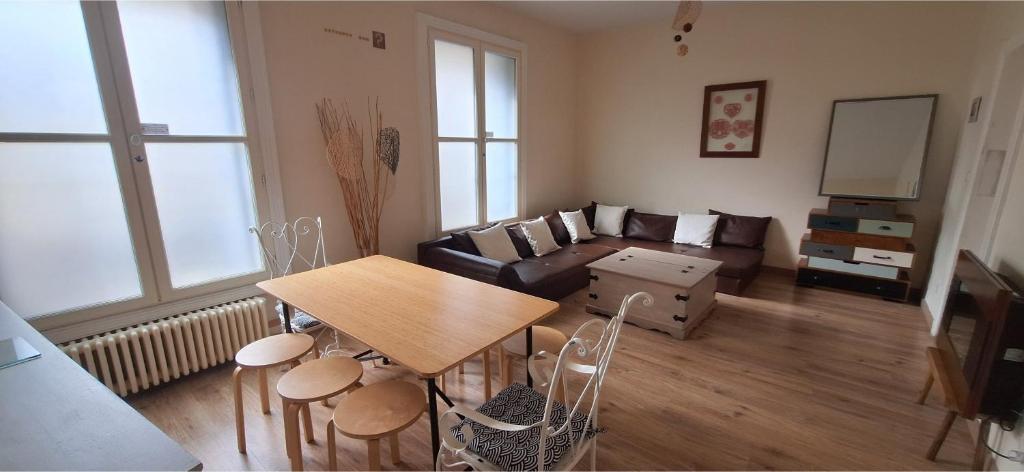 un salon avec une table et un canapé dans l'établissement 103m2 d'Espace et de Calme au coeur de Montpellier, à Montpellier