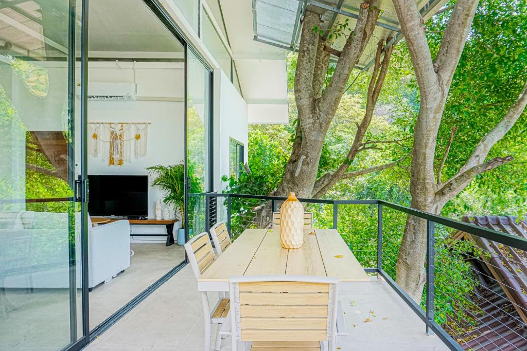 a wooden table on a balcony with a tree at Ocean Villa in Koh Phangan