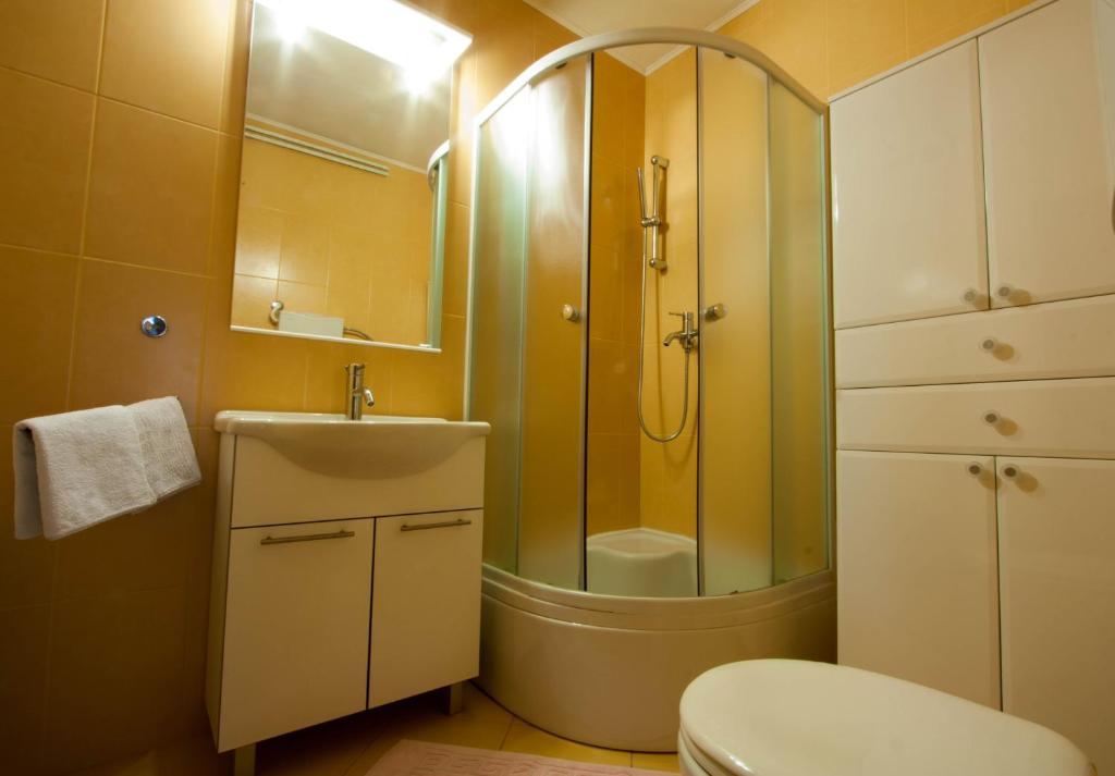 a bathroom with a shower and a toilet and a sink at Rooms & Apartments Dolac in Hvar