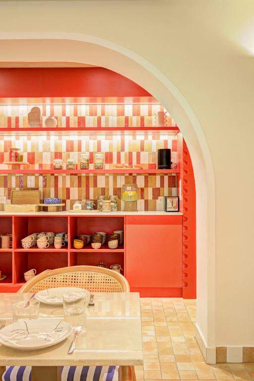 a dining room with a table and a red wall at Hôtel Gabriel in Menton