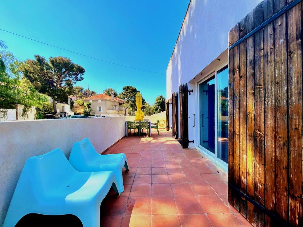 un patio avec deux bancs bleus sur un mur dans l'établissement La Villa De Port-Miou, à Cassis