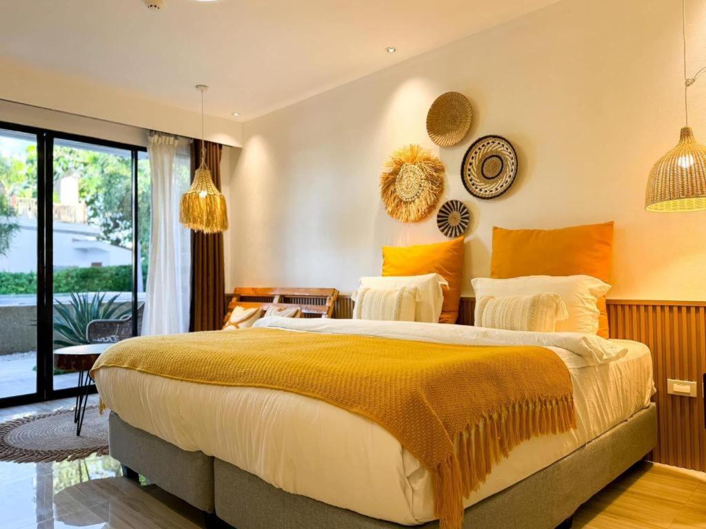 a bedroom with a large bed with yellow and orange pillows at Keep Diving Resort Bohol in Panglao