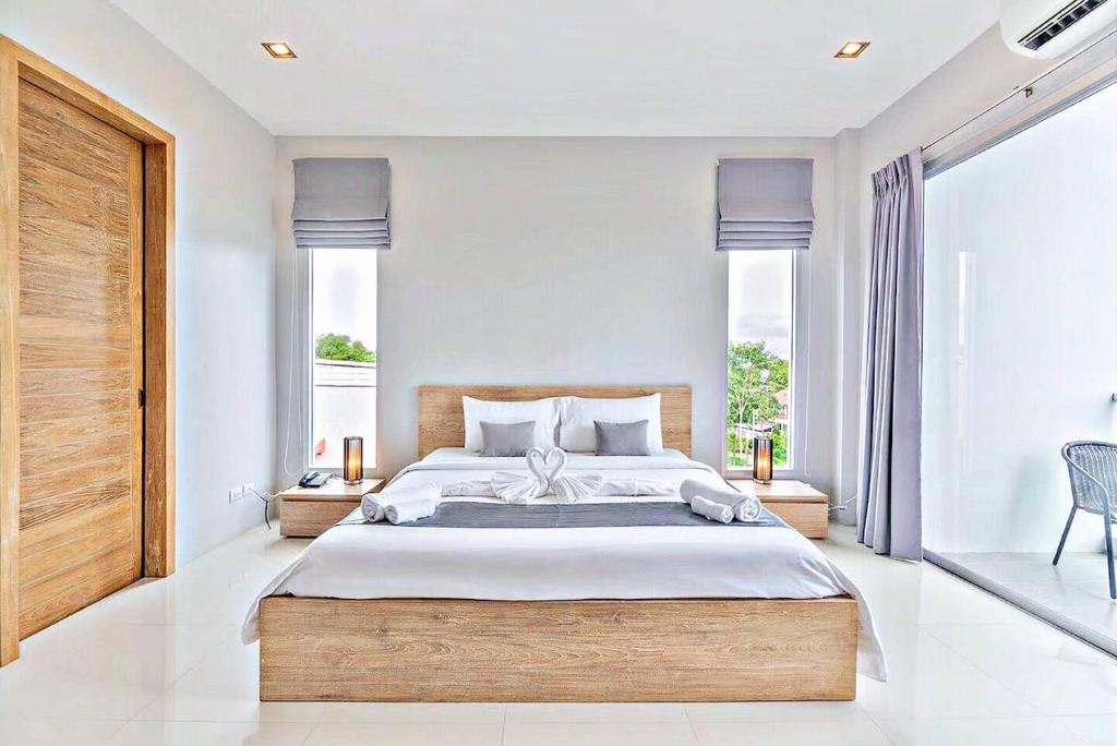 a bedroom with a large bed and a large window at Lemonade Phuket Hotel -SHA Plus in Chalong