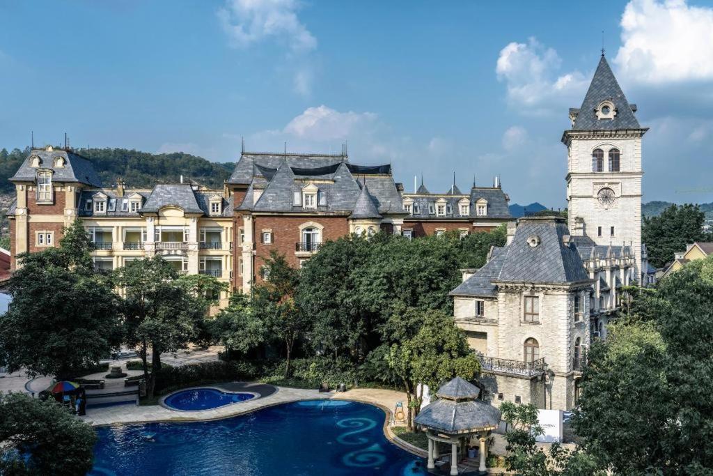 a large building with a pool in front of it at Dragon Lake Princess Hotel in Huadu