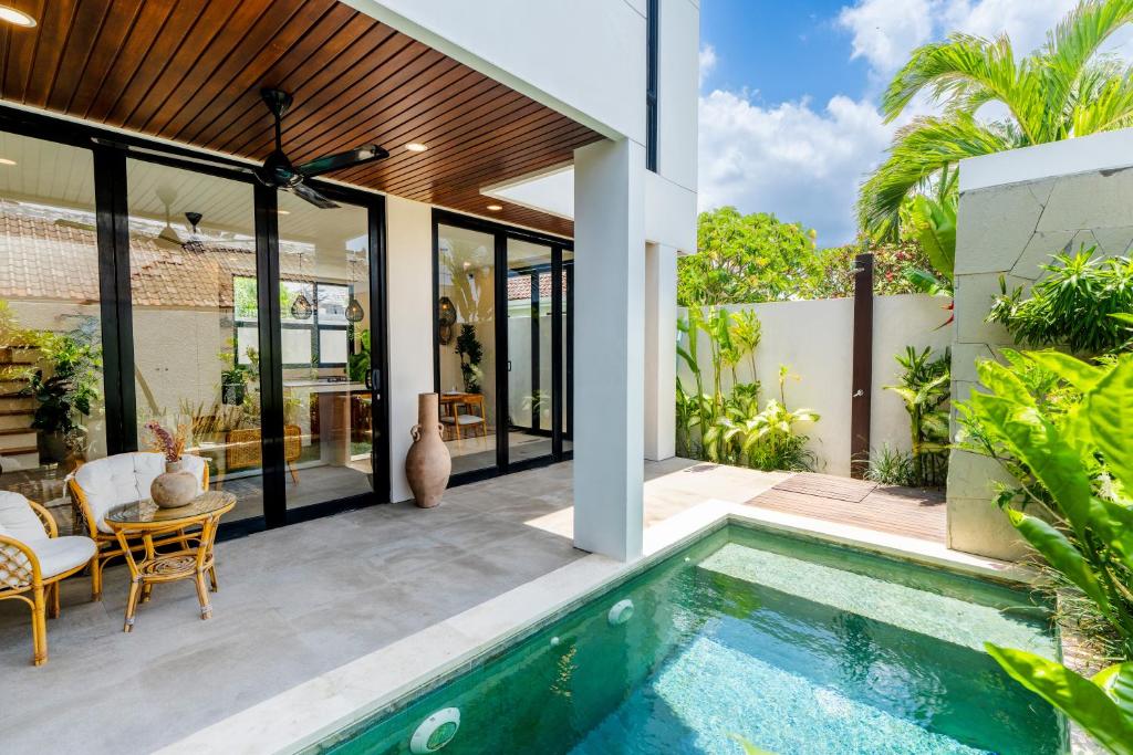 an outdoor patio with a swimming pool and a house at Villa Hati 2 in Canggu