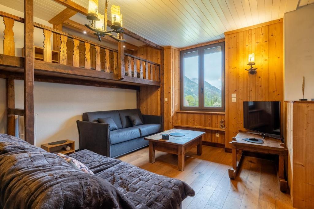une chambre avec un lit, un canapé et une télévision dans l'établissement Havre de paix entre Lac d'Annecy & Montagnes, à Alex