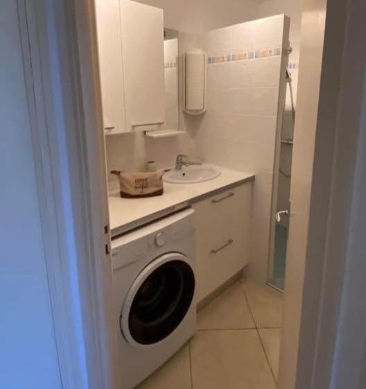 une salle de bain avec une machine à laver et un lavabo dans l'établissement Studio Arc-en-ciel, à Sète