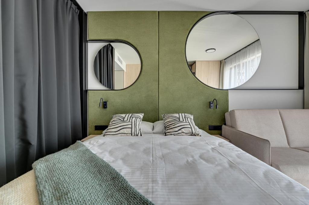 una camera con un grande letto e due specchi di GRANO APARTHOTEL Ustronie Morskie a Ustronie Morskie