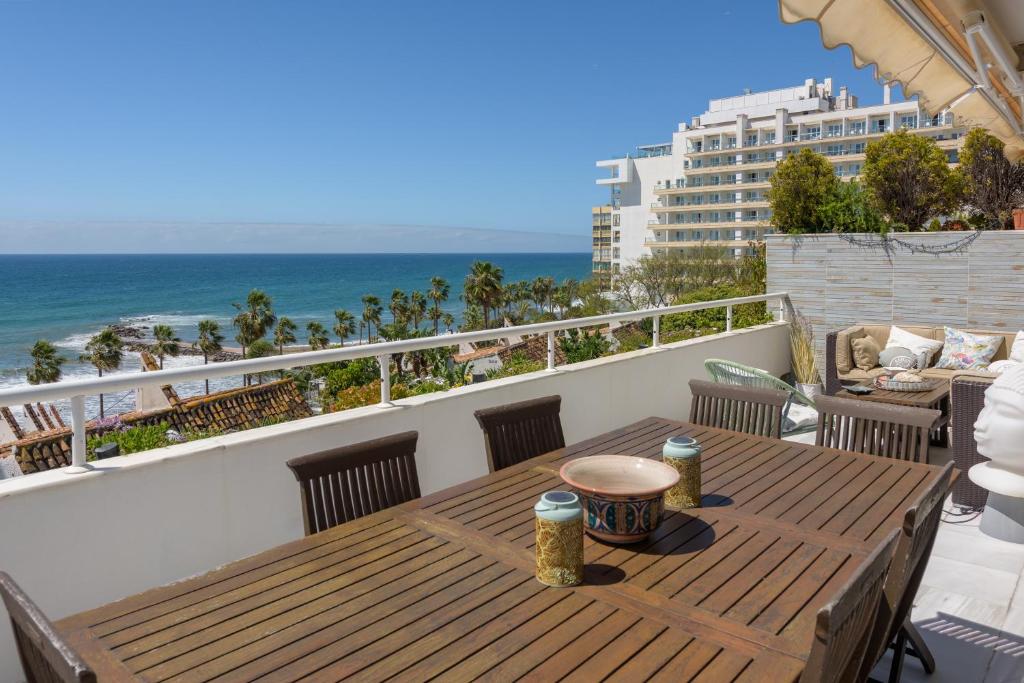 a wooden table on a balcony with a view of the ocean at Apartamento del Mar in Marbella